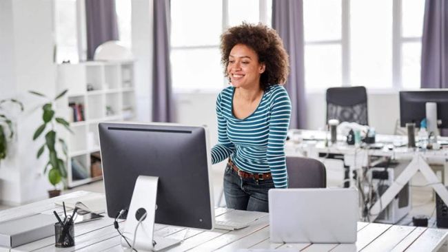 Woman smiling and dtaring into computer screen
